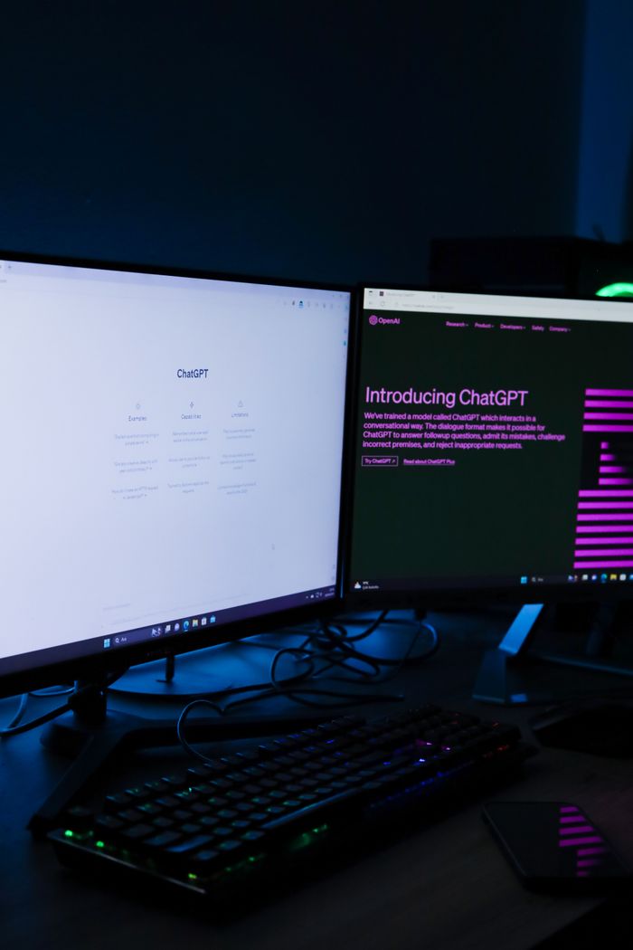 gallery-5 Vertical shot of a dual monitor setup with ChatGPT on screens, ideal for technology and AI concepts.