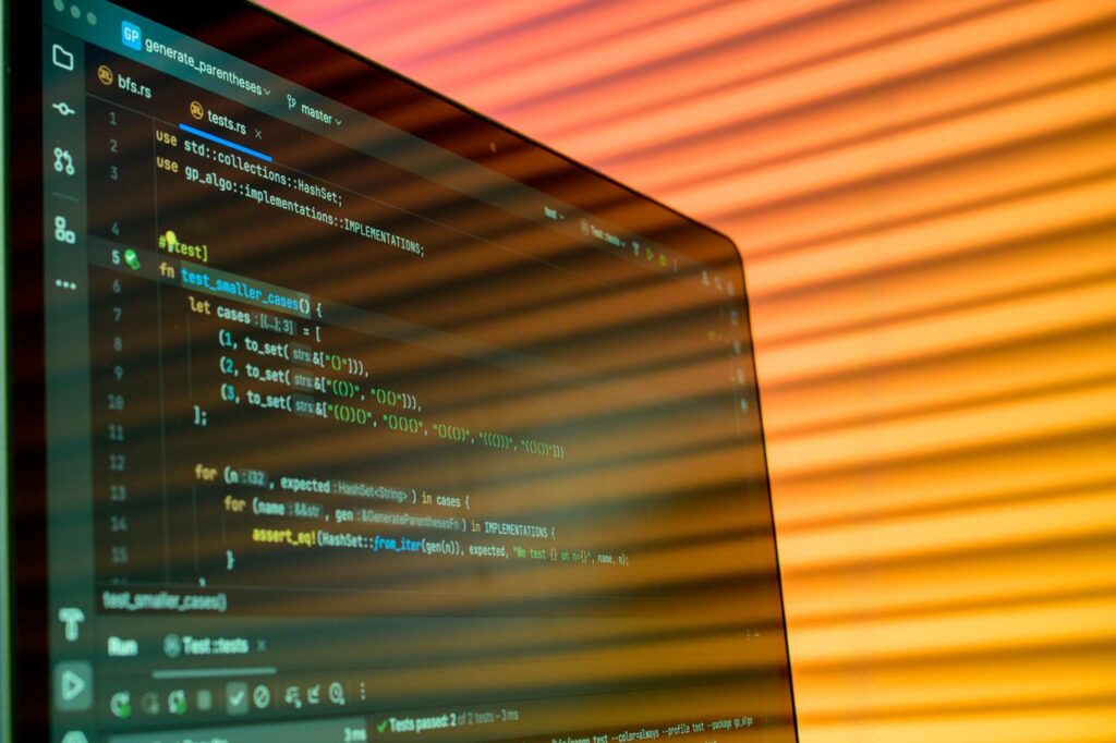 pexels photo 34804024 Blurry close-up of a computer screen displaying code with orange lighting.